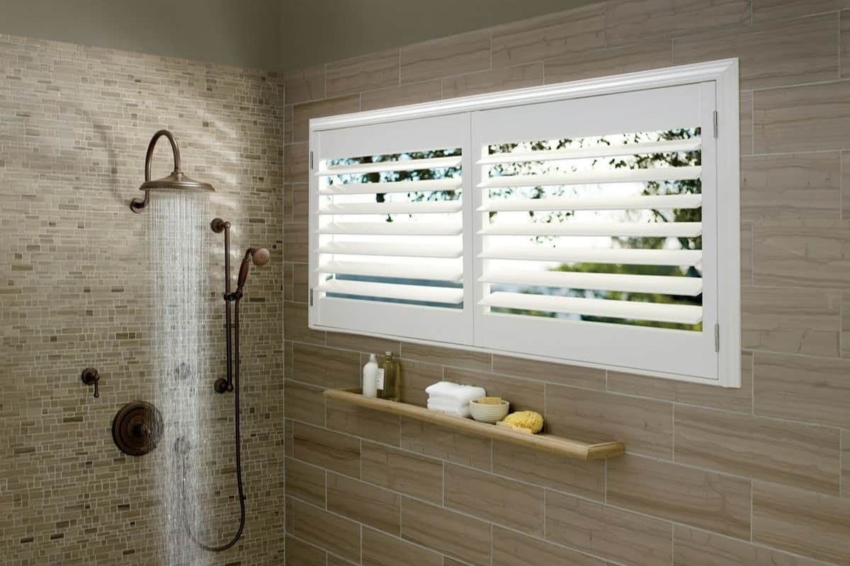 Bathroom shower with small window carrying Hunter Douglas Palm Beach™ Polysatin™ Shutters near Tacoma, Washington (WA)