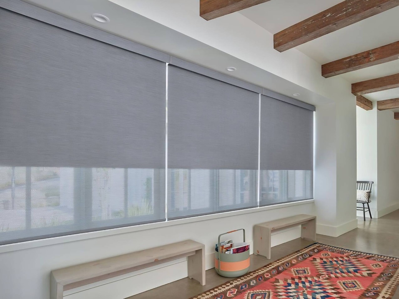 A living room with standard roll Hunter Douglas roller shades and a cornice near Tacoma, WA