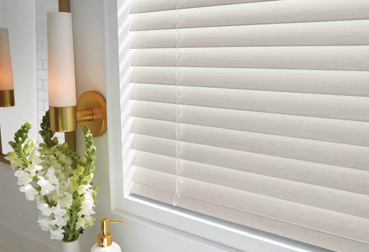 EverWood® Faux Wood Blinds for bathroom windows with white flowers in a vase and soap dispenser at Smart PNW near Tacoma, (WA)