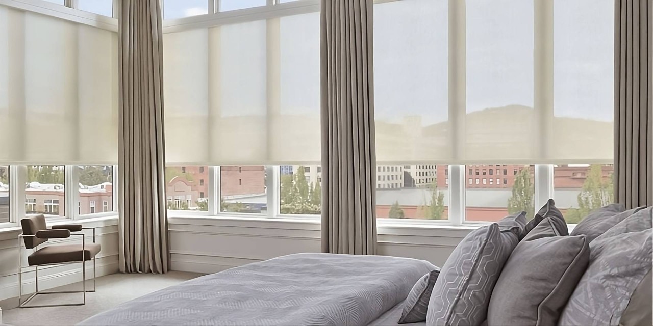 Functional and modern Hunter Douglas Designer Solar Shades on expansive windows in a stylish bedroom at Smart PNW near Tacoma, WA