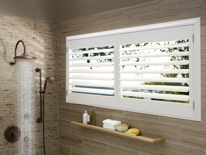 Shower and windows featuring Palm Beach™ Polysatin™ Shutters.